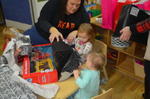 Children unwrap gifts from "Mary Breckinridge"